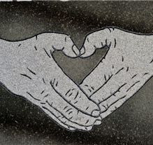 Hands forming heart shape etching on granite headstone